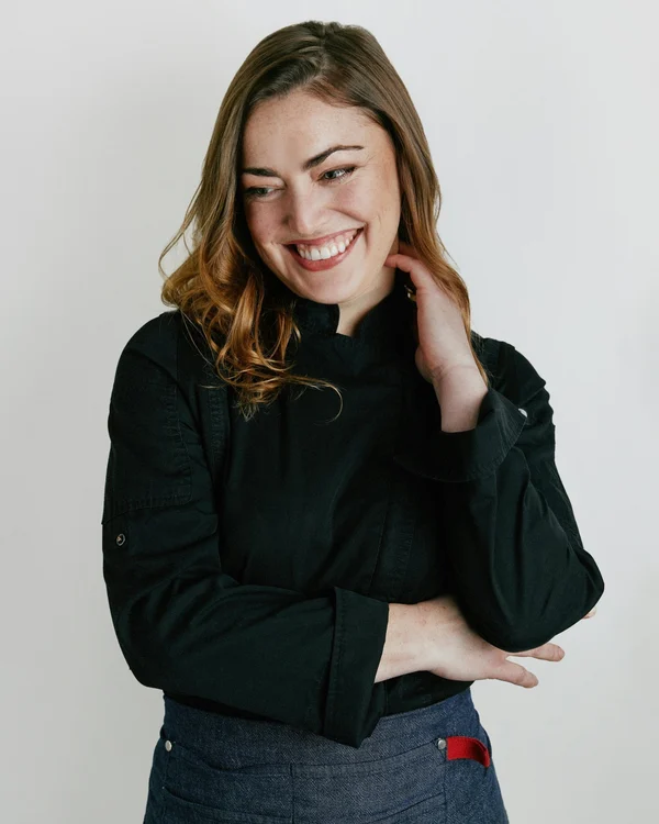 Chef Emily Peck smiling in her black chef jacket