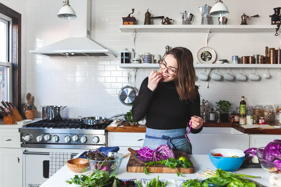 Emily tasting a dish in the kitchen