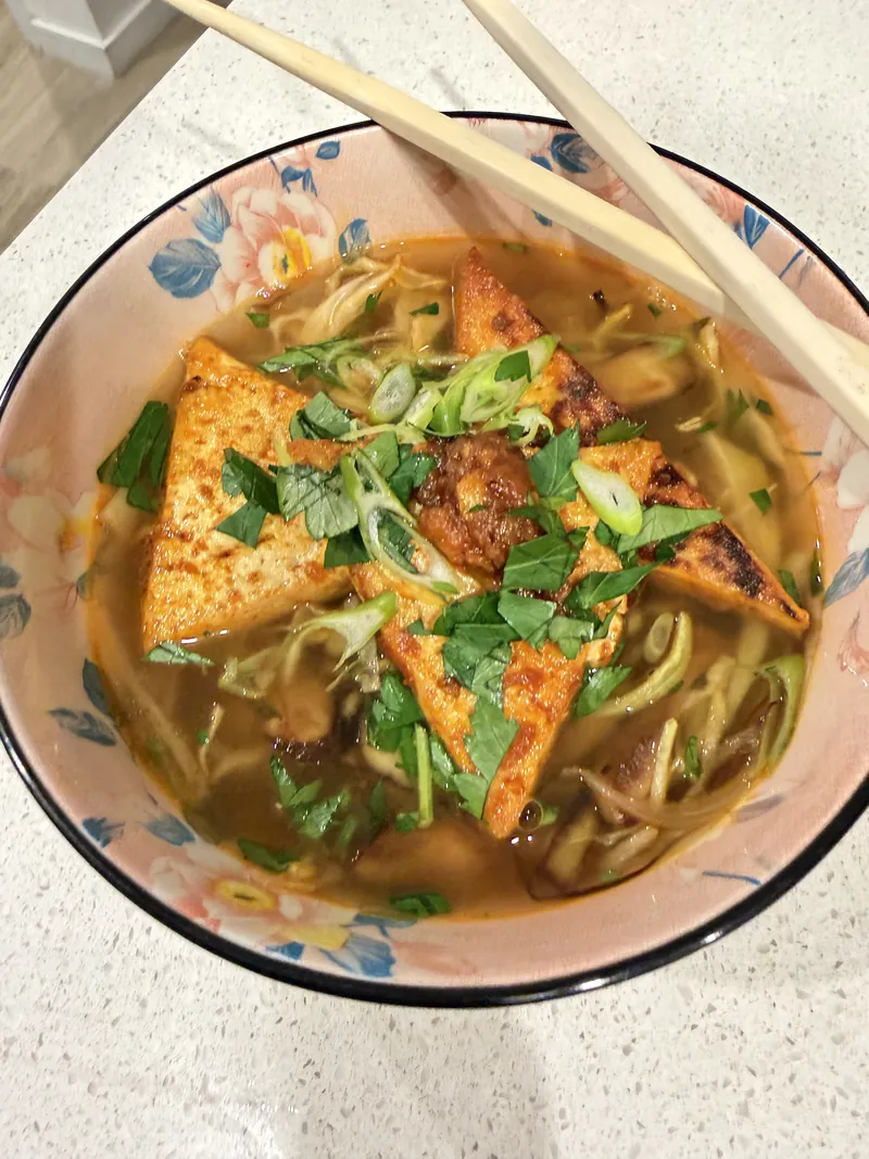 Noodle soup with crispy tofu and herbs